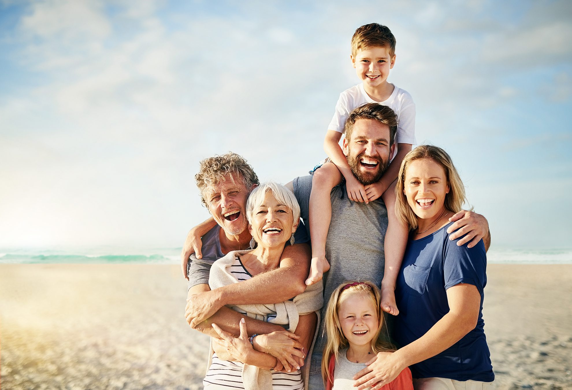 Portrait of a happy multi-generational family posing on the beach together